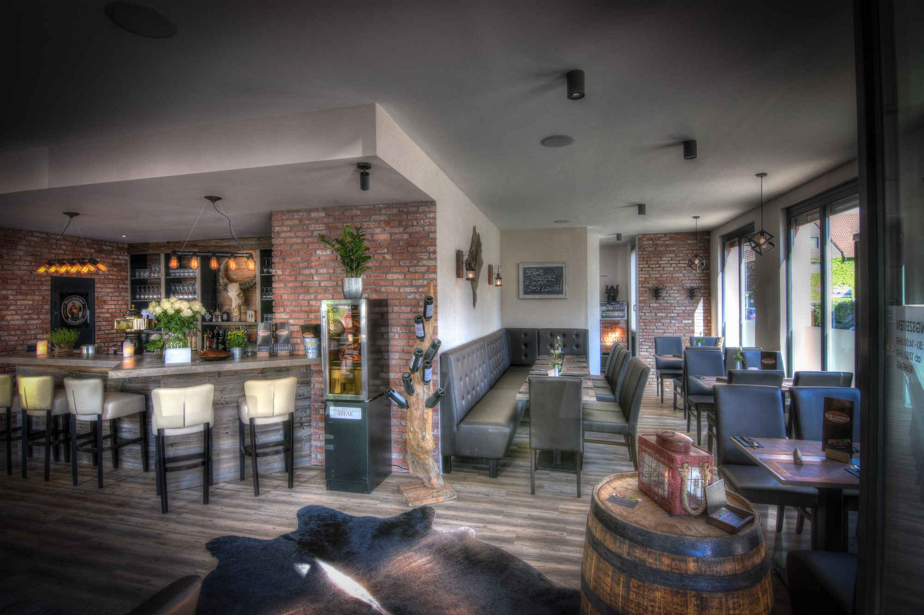 Gastraum der B&S Lounge mit Backsteinwand und Bar
